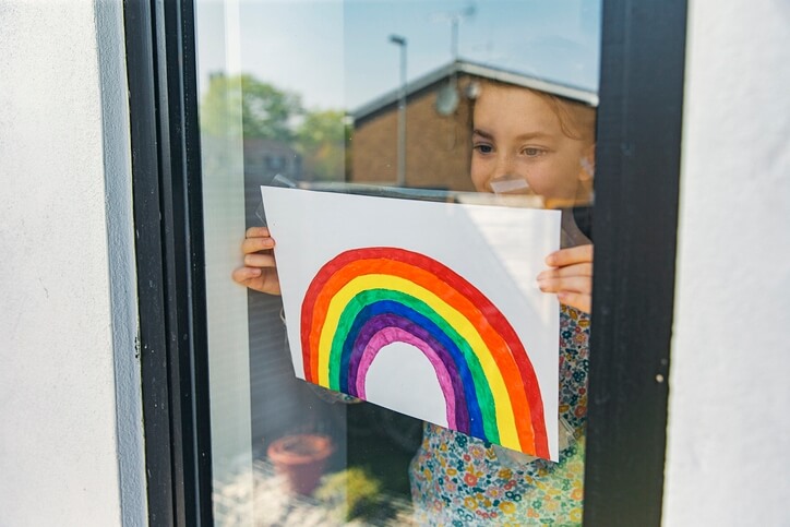 A child holding an NHS rainbow poster